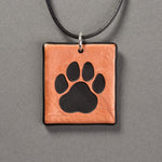 Sandcarved copper and black glass cat paw pendant.