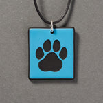 Sandcarved deep sky blue and black glass cat paw pendant.