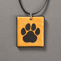 Sandcarved gold and black glass cat paw pendant.