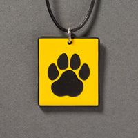 Sandcarved yellow and black glass cat paw pendant.