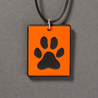 Sandcarved bright orange and black glass dog paw pendant.