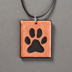 Sandcarved copper and black glass dog paw pendant.