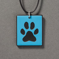 Sandcarved deep sky blue and black glass dog paw pendant.