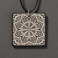 Sandcarved silver pearl and black glass flower mandala pendant.