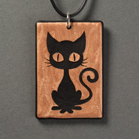 Sandcarved bronze and black glass kitty pendant.