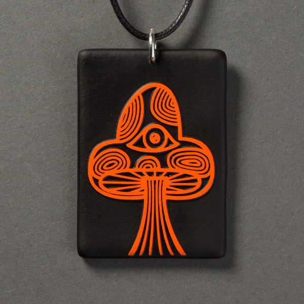 Sandcarved bright orange and black glass mushroom pendant.