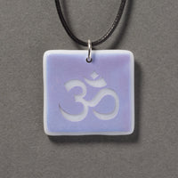 Sandcarved amethyst and white glass om pendant.