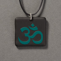 Sandcarved aquamarine and black glass om pendant.