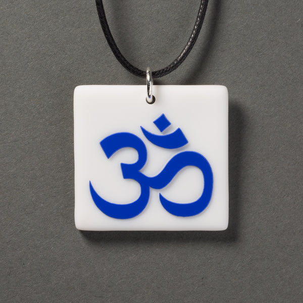 Sandcarved blue and white glass om pendant.