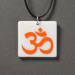 Sandcarved bright orange and white glass om pendant.