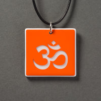 Sandcarved bright orange and white glass om pendant.