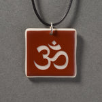 Sandcarved brown and marzipan glass om pendant.