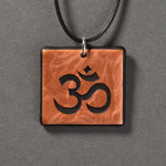 Sandcarved copper and black glass om pendant.