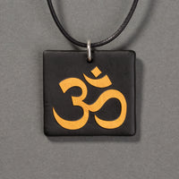 Sandcarved gold and black glass om pendant.