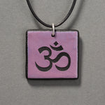 Sandcarved purple and black glass om pendant.