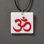 Sandcarved red and white glass om pendant.