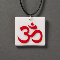 Sandcarved red and white glass om pendant.