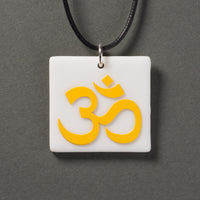 Sandcarved yellow and white glass om pendant.