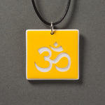 Sandcarved yellow and white glass om pendant.