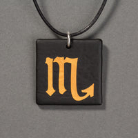 Sandcarved gold and black glass scorpio pendant.