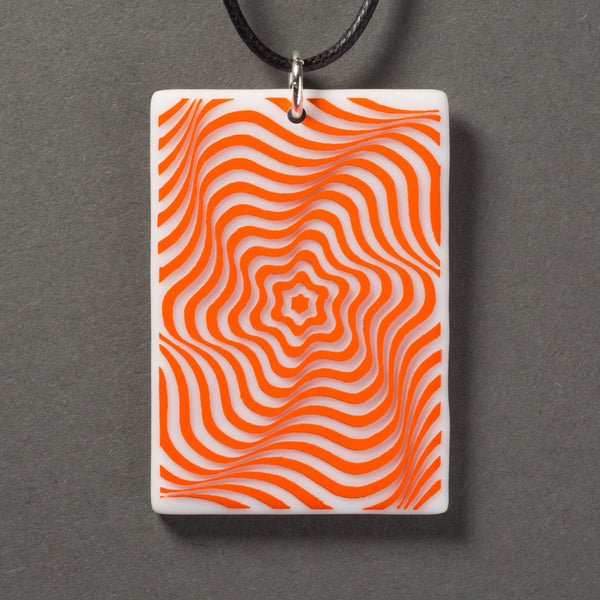 Sandcarved bright orange and white glass vortex pendant.