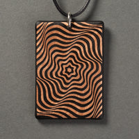 Sandcarved bronze and black glass vortex pendant.