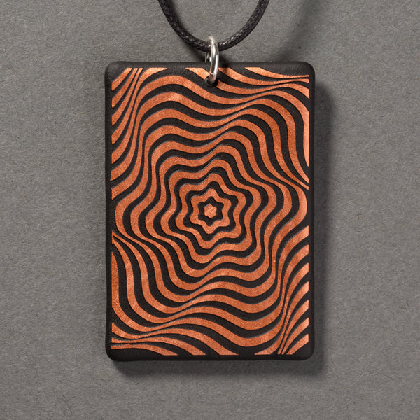 Sandcarved copper and black glass vortex pendant.