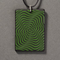 Sandcarved green and black glass vortex pendant.