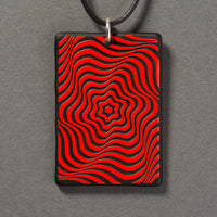 Sandcarved red and black glass vortex pendant.