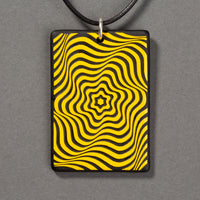 Sandcarved yellow and black glass vortex pendant.