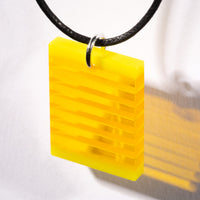 Cut and polished yellow glass layer pendant.